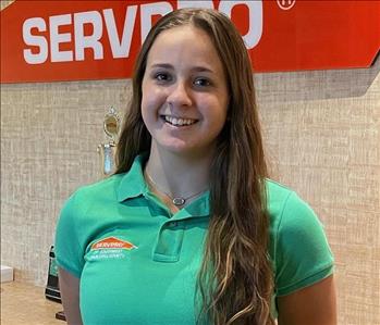 A young lady wear a SERVPRO shirt with long brown hair