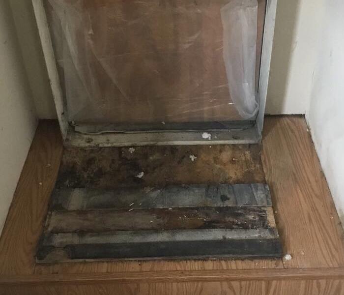 A small closet that has black mold where a furnace once was