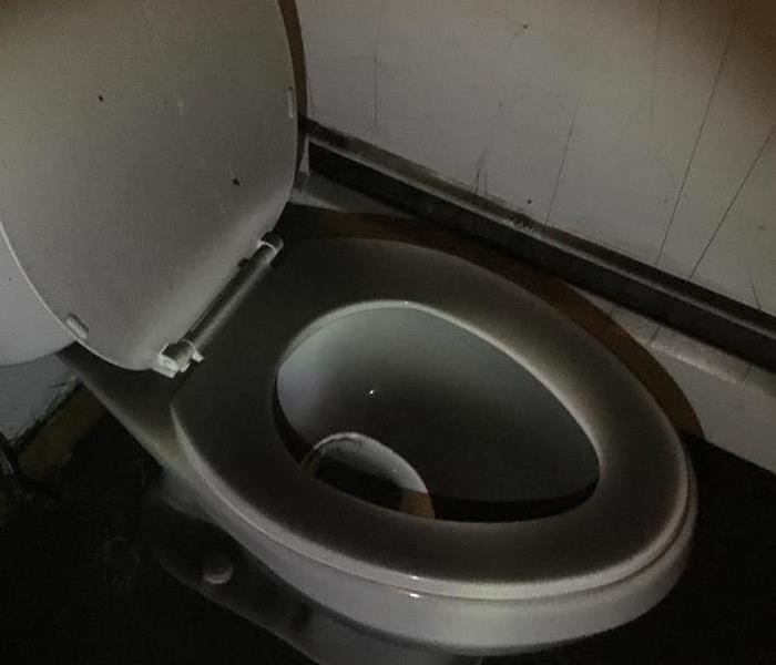 A dirty toilet with soot on it