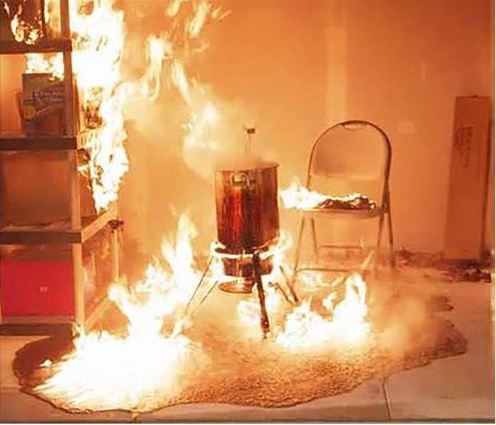 Turkey fryer on fire with the grease with contents near also on firespilled over also on fire