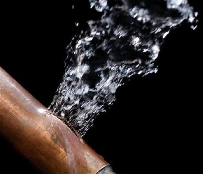 A burst copper pipe is spewing water 