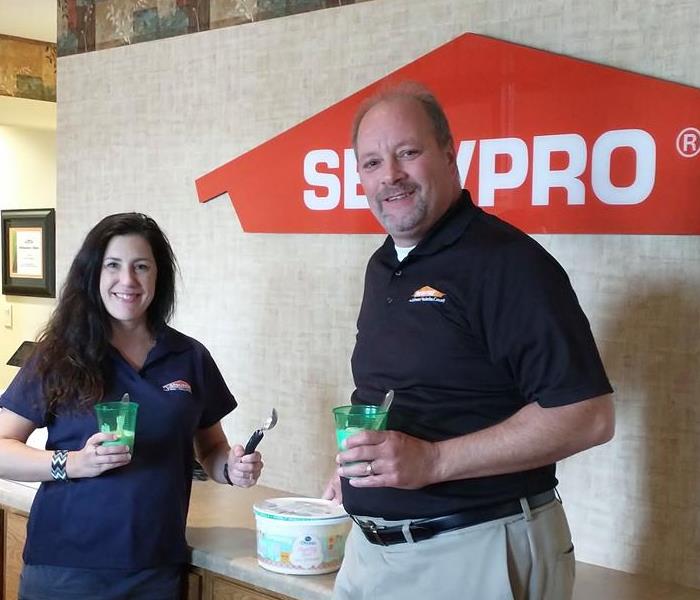 A woman wearing a blue SERVPRO polo and a man wearing a black SERVPRO polo