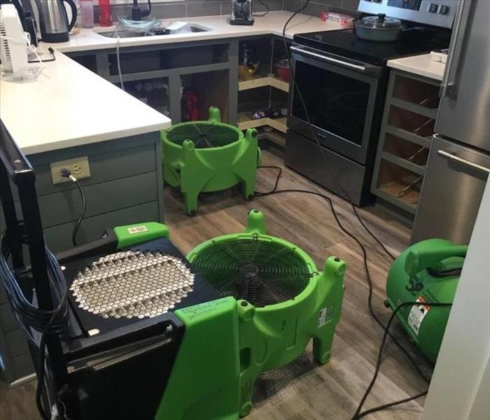 Kitchen with drying equipment from SERVPRO placed on the floor