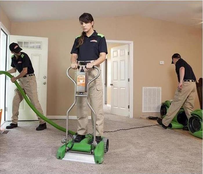 Three SERVPRO technicians are working with machinery used to clean carpets